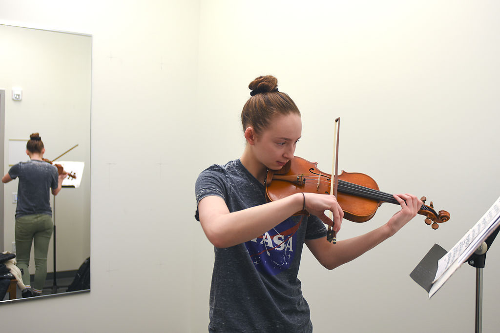 Emile Gephart practices violin in a new practice room